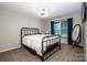 Bedroom features a metal bed frame, a window with blue curtains, and an oval mirror at 19901 Henderson Rd # M, Cornelius, NC 28031
