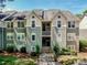 Exterior view of a two-story condominium building with light green siding, white trim and dormer windows at 19901 Henderson Rd # M, Cornelius, NC 28031