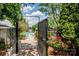 View of the community pool area through decorative metal entry gate and landscaping at 19901 Henderson Rd # M, Cornelius, NC 28031
