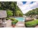 Community swimming pool overlooking a lake, surrounded by lounge chairs, tables, and lush greenery at 19901 Henderson Rd # M, Cornelius, NC 28031