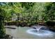 Picturesque view of the lake with a fountain and dock, surrounded by mature trees and well-manicured landscaping at 19901 Henderson Rd # M, Cornelius, NC 28031