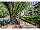 Picturesque view of a lakefront walkway, surrounded by mature trees and waterfront condominiums at 19901 Henderson Rd # M, Cornelius, NC 28031
