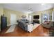 Spacious living room with hardwood floors, cozy seating, and a large TV for entertainment at 2017 White Cedar Ln, Waxhaw, NC 28173