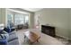 Spacious living room featuring large windows, a cozy fireplace, and comfortable seating arrangement at 2017 White Cedar Ln, Waxhaw, NC 28173