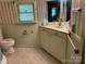 Small bathroom featuring a sink, toilet, cabinets and a light at 208 E Main St, Cleveland, NC 27013