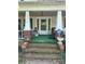 Covered front porch with brick supports and steps leading up to the entrance at 208 E Main St, Cleveland, NC 27013