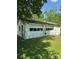View of a detached garage with peeling paint and multiple garage doors at 208 E Main St, Cleveland, NC 27013