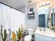 This bathroom features a single sink vanity, toilet, decorative cacti shower curtain, and chrome fixtures at 2147 Lake Breeze Ln, Denver, NC 28037