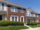 Brick townhome featuring neat landscaping, blue shutters, and an inviting entrance on a sunny day at 2147 Lake Breeze Ln, Denver, NC 28037