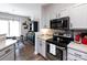 Stylish kitchen featuring gray cabinets, stainless steel appliances, and hardwood floors with breakfast nook at 2147 Lake Breeze Ln, Denver, NC 28037