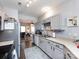 Well-lit kitchen featuring gray cabinets, laminate countertops, stainless steel appliances, and hardwood floors at 2147 Lake Breeze Ln, Denver, NC 28037