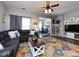 Spacious living room featuring hardwood floors, a large sofa, a colorful rug, and lots of natural light at 2147 Lake Breeze Ln, Denver, NC 28037