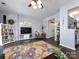 Bright living room with hardwood floors, a large sofa, a colorful rug, and a TV at 2147 Lake Breeze Ln, Denver, NC 28037