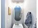This powder room features an oval mirror, modern lighting, and stylish decor at 2147 Lake Breeze Ln, Denver, NC 28037
