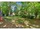 Lush backyard with a spacious lawn, mature trees, and a storage shed on the property at 232 Scottridge Dr, Charlotte, NC 28217
