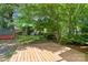 Expansive backyard featuring a wood deck, lush lawn, mature trees, and a storage shed at 232 Scottridge Dr, Charlotte, NC 28217