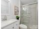 Modern bathroom with granite countertop, framed mirror and tiled glass shower with decorative plant at 232 Scottridge Dr, Charlotte, NC 28217
