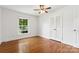 This bedroom features hardwood floors, a ceiling fan, a window, and a closet at 232 Scottridge Dr, Charlotte, NC 28217