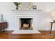 Close-up of a cozy fireplace with white mantel, hardwood floors, and elegant details at 232 Scottridge Dr, Charlotte, NC 28217