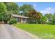 Charming home with brick facade, lush front lawn, mature trees, and private driveway at 232 Scottridge Dr, Charlotte, NC 28217