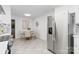 Bright kitchen with stainless steel appliances, a dining table, and updated tile flooring at 232 Scottridge Dr, Charlotte, NC 28217