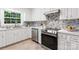 Modern kitchen with white cabinets, stainless steel appliances, and stylish backsplash at 232 Scottridge Dr, Charlotte, NC 28217
