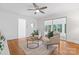 Bright living room with hardwood floors, a ceiling fan, and sliding glass doors to the sunroom at 232 Scottridge Dr, Charlotte, NC 28217