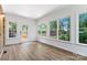 Bright sunroom with lots of windows and wood-look laminate floors, with exterior access at 232 Scottridge Dr, Charlotte, NC 28217