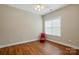 Well-lit bedroom featuring beautiful hardwood floors, a ceiling fan, and a bright window at 2323 Granville Pl # A, Monroe, NC 28110