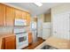 Bright kitchen boasts hardwood floors, wooden cabinets and white appliances at 2323 Granville Pl # A, Monroe, NC 28110