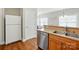 Kitchen area with stainless steel dishwasher, double sink, wood cabinetry, and white refrigerator at 2323 Granville Pl # A, Monroe, NC 28110