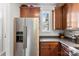 Kitchen features stainless steel refrigerator, wood cabinets, granite counters, and a window at 2485 Shanklin Ln, Denver, NC 28037