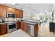 The kitchen showcases stainless steel appliances, wood cabinets, a microwave, and an open layout at 2485 Shanklin Ln, Denver, NC 28037