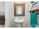 Cozy powder room featuring a pedestal sink, decorative mirror, and industrial-style towel rack at 2485 Shanklin Ln, Denver, NC 28037