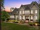 Elegant two-story home featuring a stone foundation, inviting porch, and manicured lawn at twilight at 270 Kemp Rd, Mooresville, NC 28117