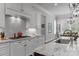 Close-up of kitchen featuring a cooktop, white cabinets, granite countertop and stainless sink at 270 Kemp Rd, Mooresville, NC 28117