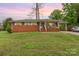 Charming red brick home featuring a cozy front porch and a convenient carport with a well-maintained lawn at 2885 Wright Ave, Salisbury, NC 28147