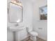 Bright bathroom featuring a pedestal sink, toilet, framed mirror and a window at 318 Sixth St, Belmont, NC 28012