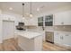 Bright kitchen features a center island, stainless steel appliances and sleek white cabinetry at 318 Sixth St, Belmont, NC 28012