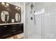 Stylish bathroom featuring a sleek glass shower and a modern vanity with double sinks and hexagon backsplash at 324 Elm St, Belmont, NC 28012