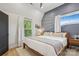 Stylish bedroom with a blue accent wall, white curtains, and natural light from two windows at 324 Elm St, Belmont, NC 28012