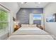 Serene bedroom featuring a light blue accent wall, large windows, and contemporary decor at 324 Elm St, Belmont, NC 28012