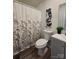 Bathroom featuring floral shower curtain, toilet, vanity with gray cabinets and stylish blue floral wall art at 5010 Hemphill Rd, Gastonia, NC 28056