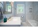 Bright bathroom featuring a white sink and vanity, tiled shower, and silver fixtures at 5100 Crestland Ave, Charlotte, NC 28269
