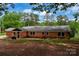 Exterior of a brick home with a large backyard and mature trees creating a private setting at 5100 Crestland Ave, Charlotte, NC 28269