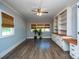 Spacious living room with a ceiling fan, wood floors, and built in shelving and cabinets at 5100 Crestland Ave, Charlotte, NC 28269