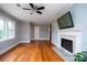 Bright living room with refinished hardwood floors, a decorative fireplace, and large windows for ample natural light at 5100 Crestland Ave, Charlotte, NC 28269