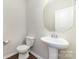 A half bathroom features a pedestal sink, toilet, and a decorative mirror in a neutral color scheme at 532 Dalkeith Ave, Rock Hill, SC 29732