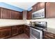 Close-up view of the kitchen featuring dark wood cabinetry, stainless steel appliances, and granite countertops at 532 Dalkeith Ave, Rock Hill, SC 29732