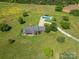 Aerial view of property showcasing the house, pool, surrounding land, and mature trees at 5873 Alexis Ln, Vale, NC 28168